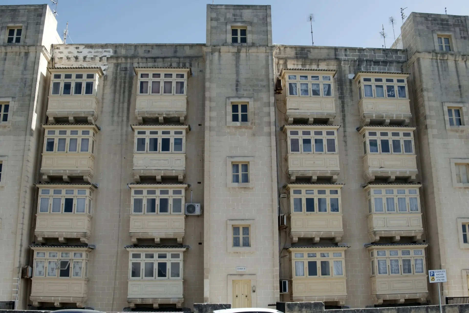 Rasterfassade mit vielen gleichen Fenstern und Balkonen