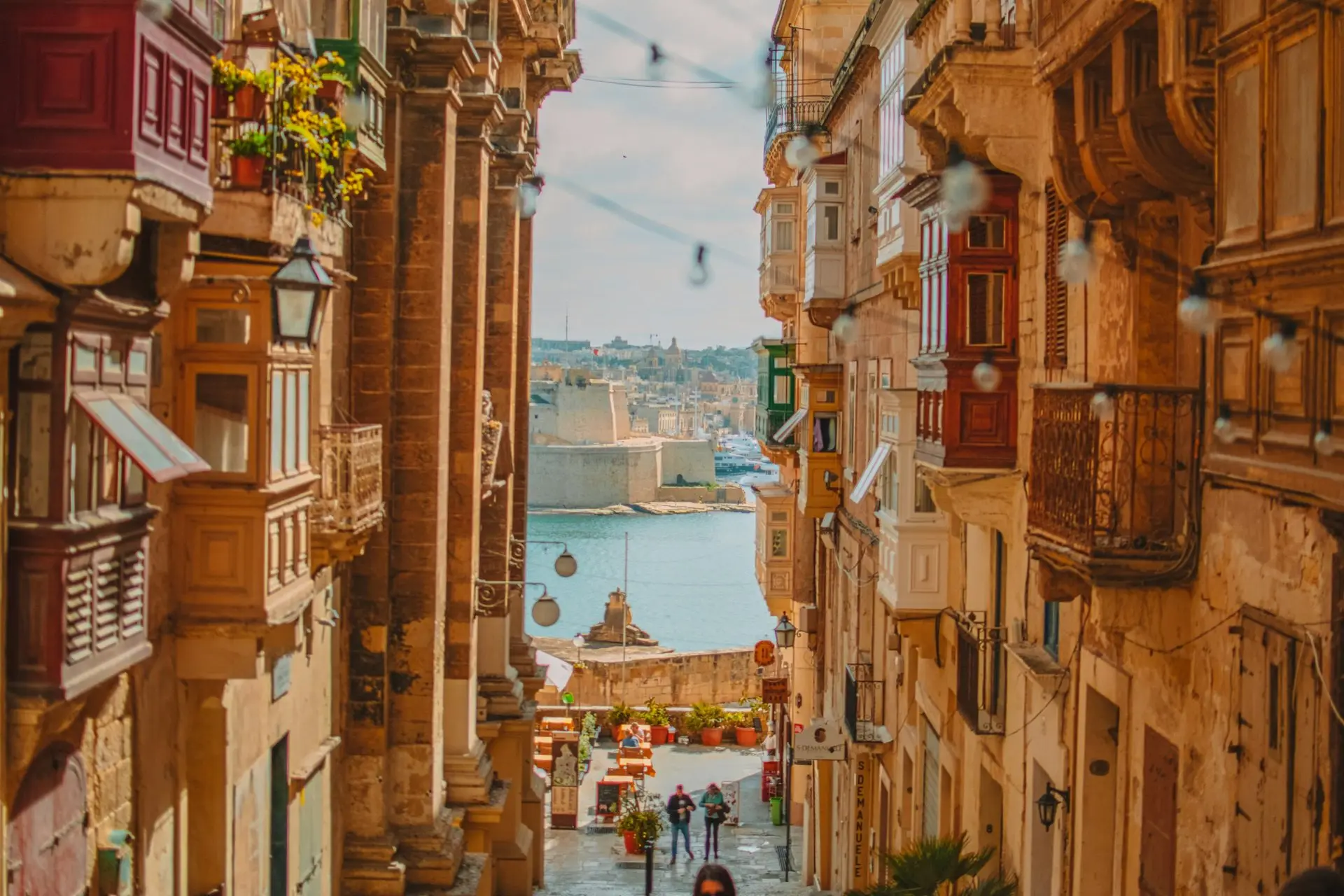 Valletta-Gasse mit traditionellen Holzbalkonen, Blick zum Hafen