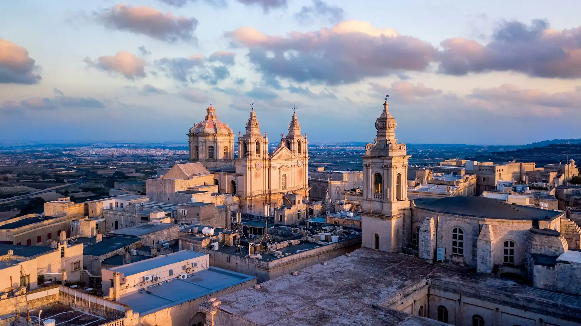 Die Skyline von Mellieha mit Kirchenkuppel im Abendlicht