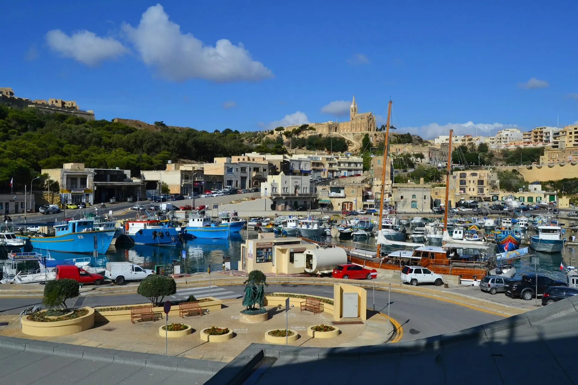 Der Hafen von Mgarr auf Gozo mit Booten und Hügelkirche