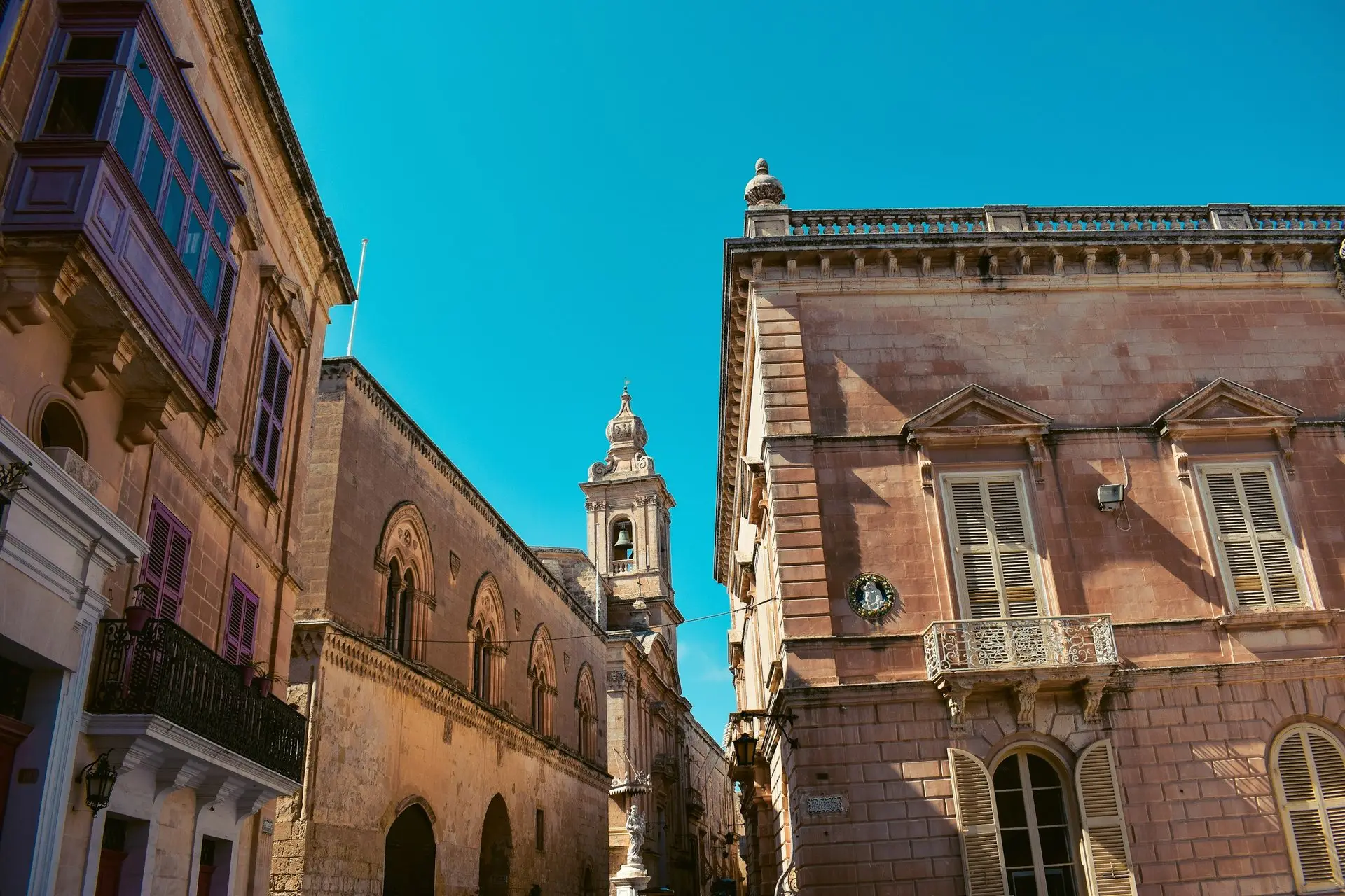 Palastfassaden und ein Kirchturm über einer Gasse