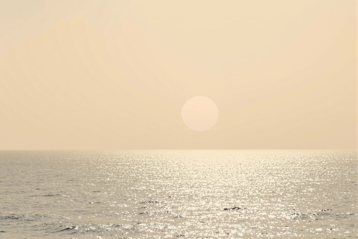 Dunstige Sonne über flimmerndem Meer