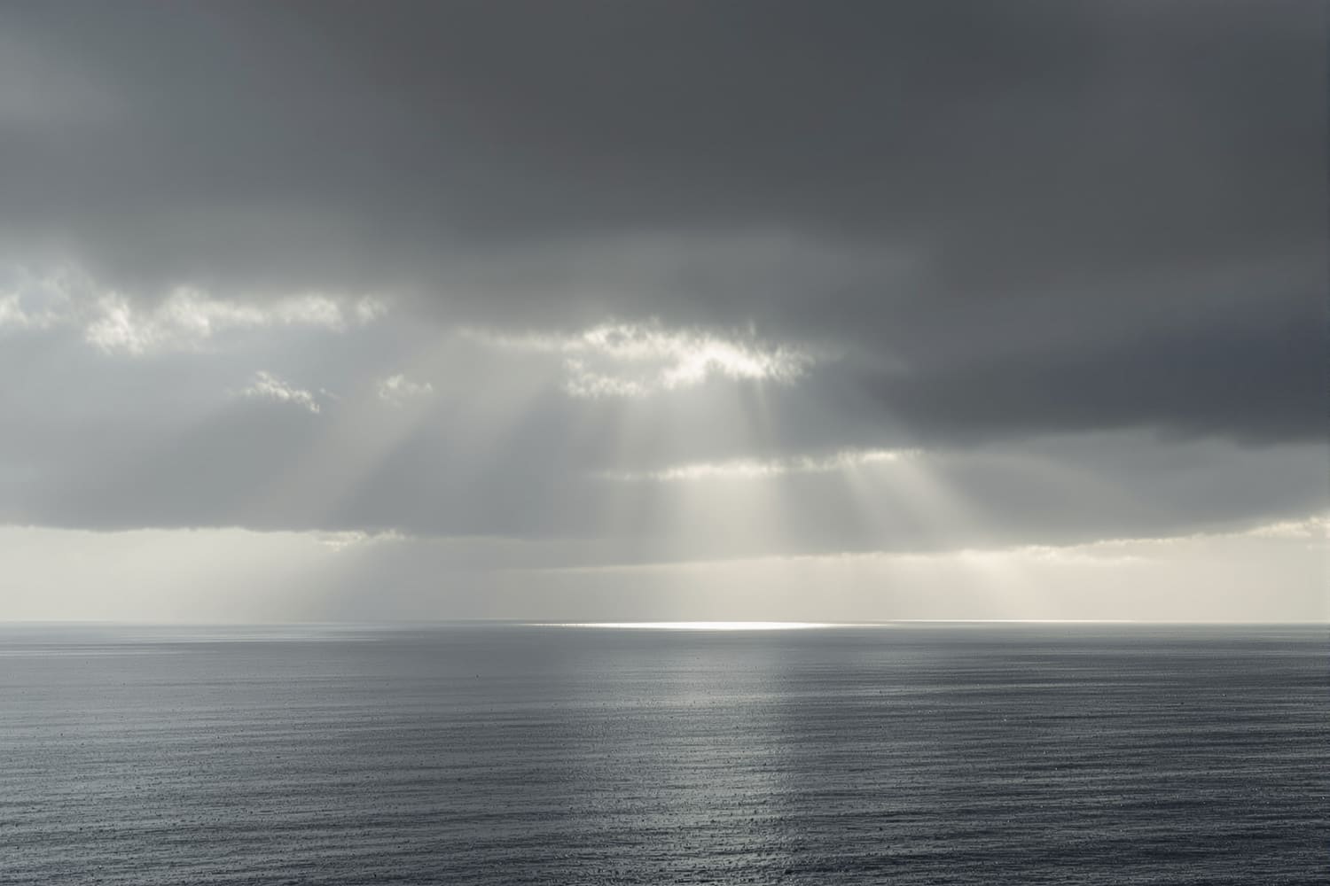 Lichtstrahlen brechen durch Wolken über dem Meer