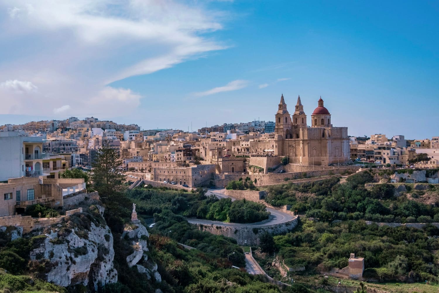 Blick auf Mellieħa mit seiner Pfarrkirche über grünen Hängen